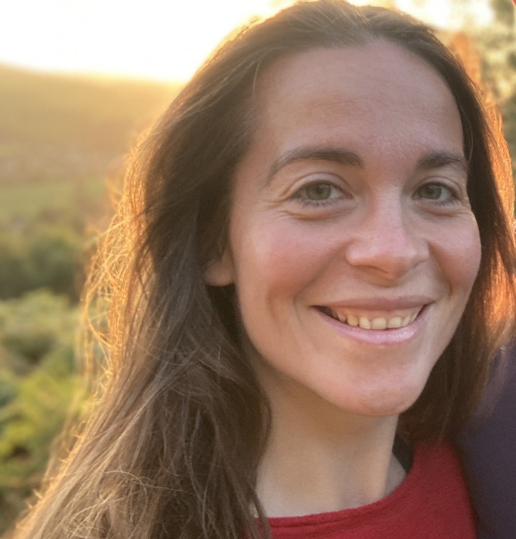 Bethan Perkins Woman smiling at camera with sun behind