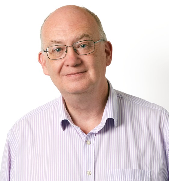 Man with glasses smiling at camera