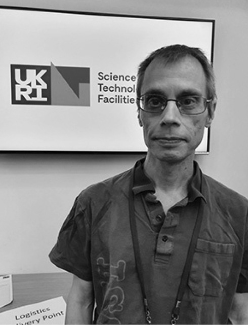 Man in glasses looking at camera with UKRI logo behind