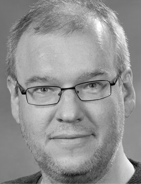 Headshot of man in glasses looking at camera