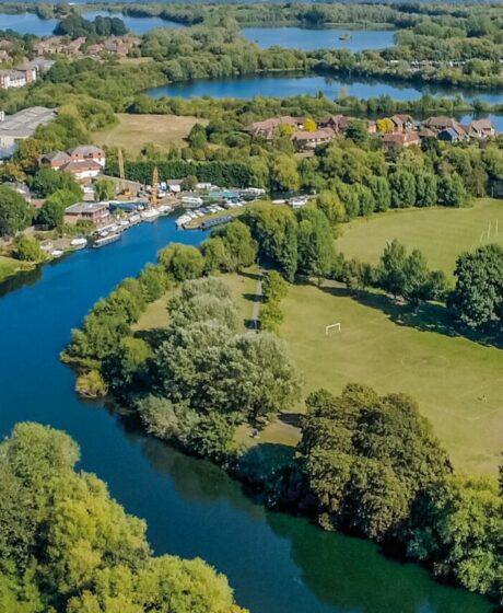 Birds eye view of river through houses and fields